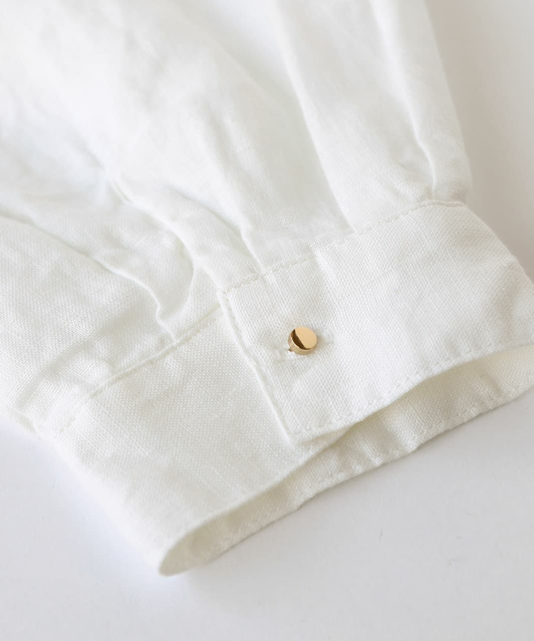袖口にあしらったゴールドのボタン